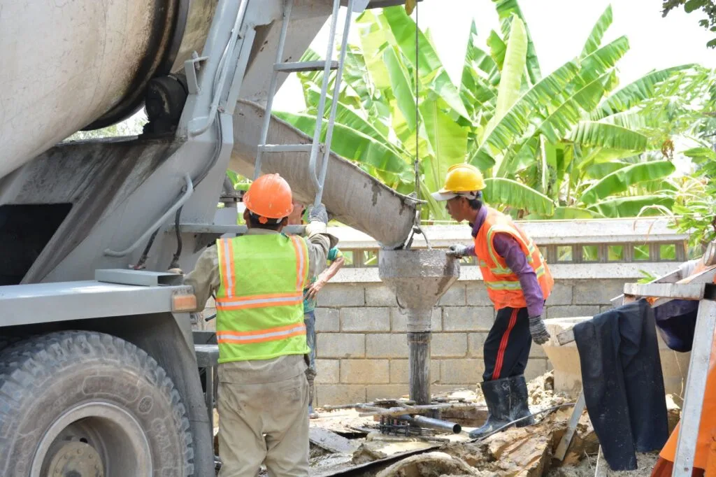 Concrete crew placing concrete from a mixer truck chute on a job site