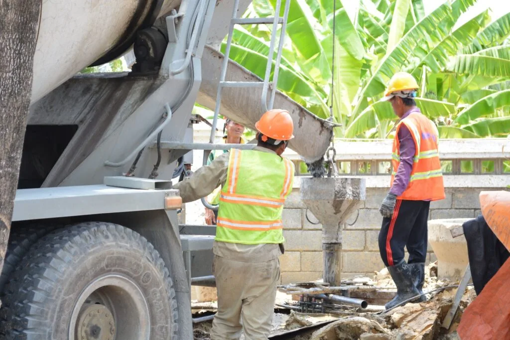 Concrete pouring from a mixer truck chute at a job site
