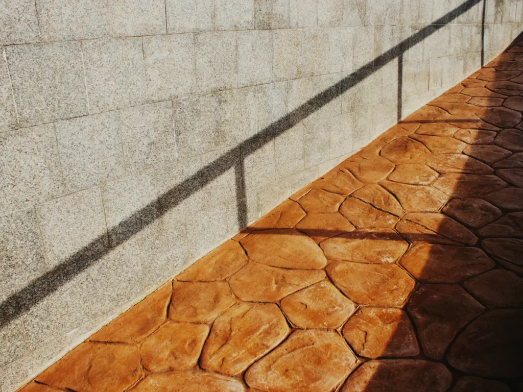 Stamped concrete walkway with a tan flagstone pattern in afternoon light
